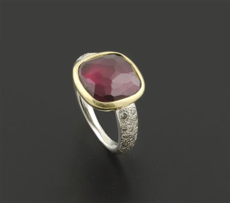 Anello Pomellato in oro bianco e giallo con tormalina rossa ai lati...
