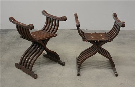 Coppia di sgabelli richiudibili del tipo “Savonarola” in legno intagliato a...