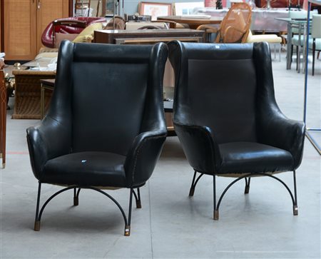 Due poltrone imbottite rivestite in semipelle nera, con struttura in tondino...