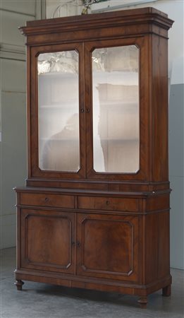 Mobile a due corpi lastronato in noce con parte superiore a due ante a vetri....