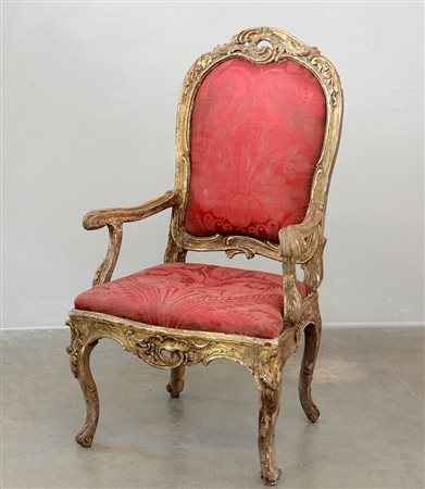 Poltrona in legno intagliato e dorato con cartella e fascia traforate. Gambe...