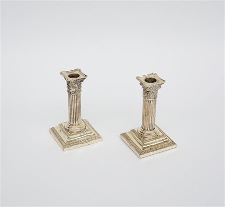 Coppia di candelieri in argento a forma di colonna con basamento quadrato....
