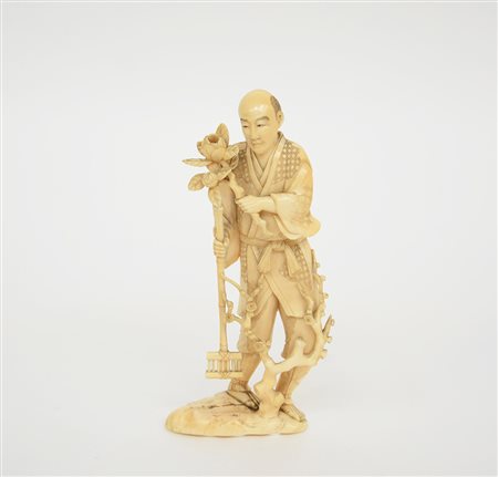 Okimono in avorio raffigurante un giardiniere con ramo di peonia, firma alla...