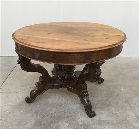 Tavolo tondo allungabile in noce con quattro gambe intagliate a volute,...