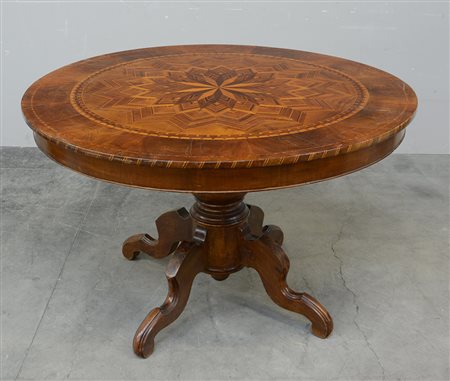 Tavolo con piano tondo lastronato in noce, intarsiato a motivo di rosone e...