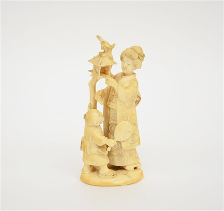 Okimono in avorio raffigurante una figura femminile con bambino che pone un...