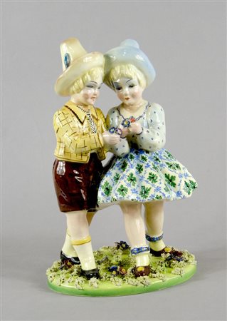 Scultura in ceramica policroma raffigurante piccoli amanti. Anni '30. H. cm. 30.