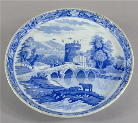 Piatto in ceramica bianca e azzurra con veduta di paesaggio con ponte al...