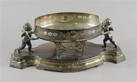 Centrotavola di forma ovale in metallo argentato con 2 figure di putti. Lung....