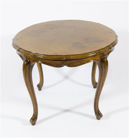 Tavolino basso rotondo su gambe a sciabola.