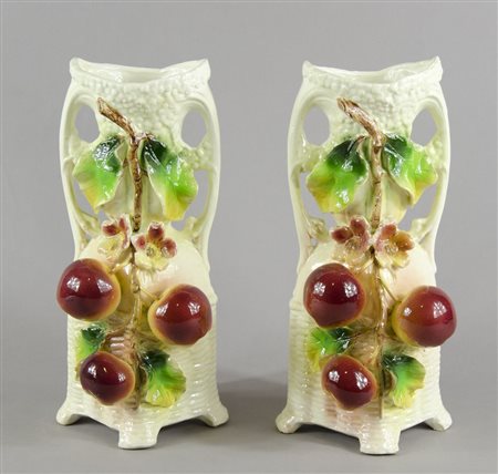 Coppia di vasi in ceramica policroma con frutta in rilievo. H. cm. 38.