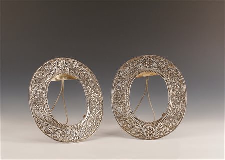 Coppia di cornici ovali in argento traforato a motivo floreale, gr. 635, cm....