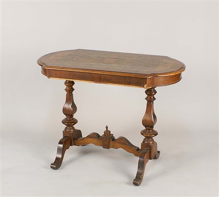 Scrittoio in noce, piano sagomato poggiante su gambe a balaustro e riunite al...