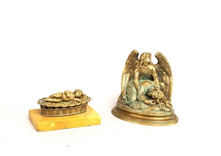 Lotto composto da due gruppi in bronzo dorato raffiguranti un bimbo entro una...