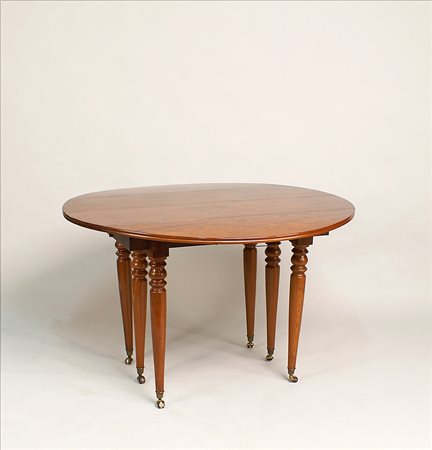 Tavolino a bandelle allungabile in mogano fiorito poggiante su sostegni a...