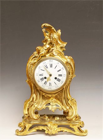 Orologio da camino in bronzo dorato, cesellato e decorato a motivo di...