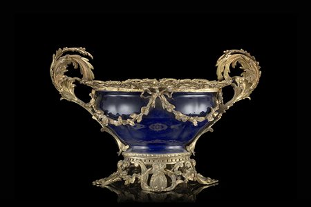 Manifattura del secolo XIX. Centrotavola in porcellana a fondo blu con ghiere...