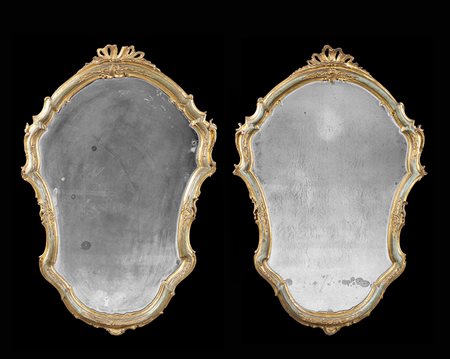 Coppia di specchiere di forma sagomata in legno intagliato e dorato con...