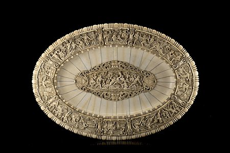 Grande piatto di forma ovale lastronato in avorio e decorato a scene...