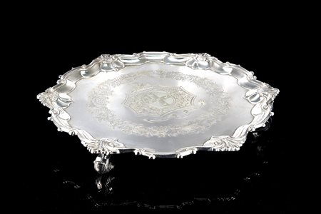 Salver in argento con fondo cesellato da fascia di motivi floreali e volute...