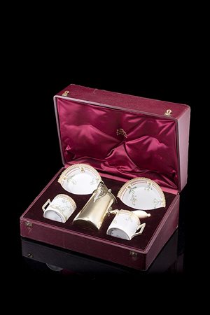 Servizio in custodia composto da una cioccolatiera in argento dorato a corpo...