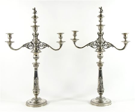 Coppia di grandi candelabri in argento finemente lavorati a sbalzo a palmette...