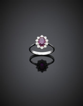 Anello in oro bianco con rubino ovale centrale di ct. 0,90 circa, contornato...