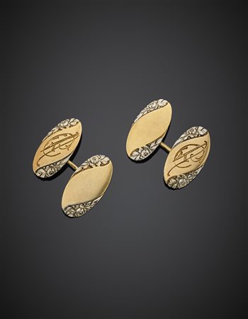 Gemelli in oro giallo e bianco con rose incise, g 8,77. Iscrizione sul retro:...