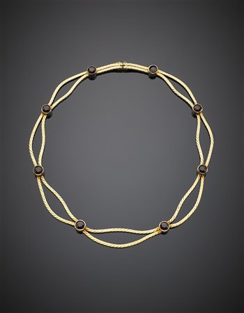 Collier in oro giallo a due fili piatti festonati, distanziati da granati...