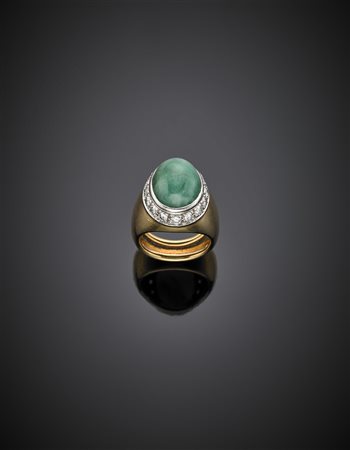 Anello in oro giallo e bianco, con diamanti a contornare uno smeraldo ovale...