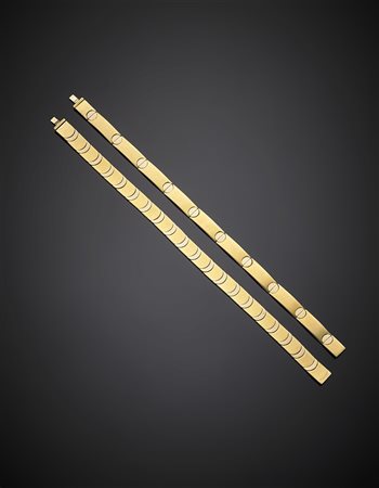 Due bracciali modulari in oro giallo e bianco a cerniere invisibili,...