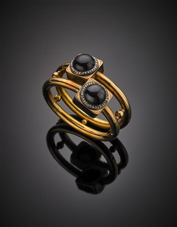 Bracciale rigido a doppio tubo rifinito con due granati cabochon rotondi...