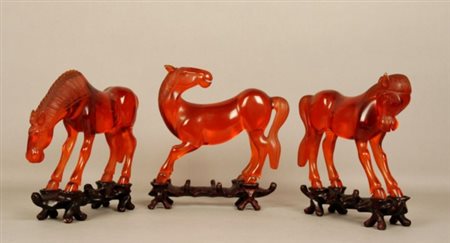 Firmato. Tre sculture in resina naturale raff. ''CAVALLI''. Cina. XX secolo....