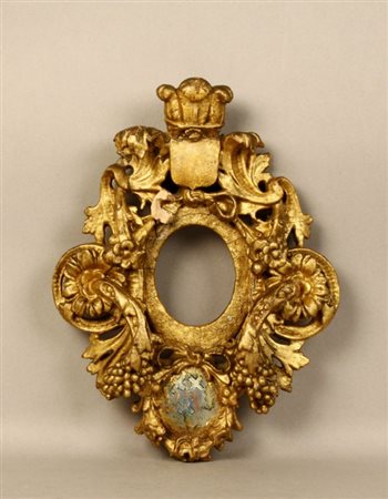 Particolare cornice in legno intagliata e dorata a foglia con motivi floreali...