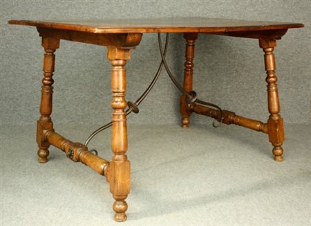 Firmato, datato. Tavolo in legno esotico, gambe tornite unite da due ferri....