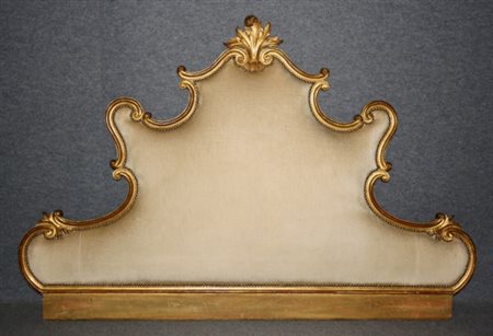 Firmato, datato. Testata da letto imbottita con cornice in legno intagliato e...