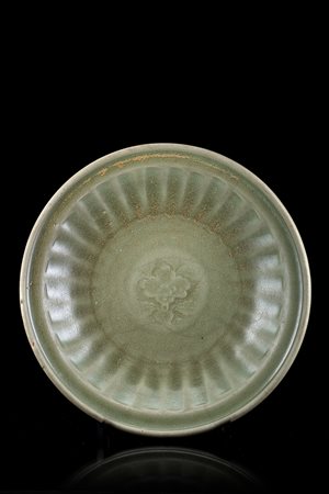 Piatto in gres celadon con decorazione floreale incisaCina, dinastia Ming...