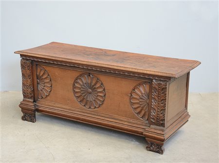 Cassapanca in noce con montanti intagliati a motivi vegetali, fronte decorato...