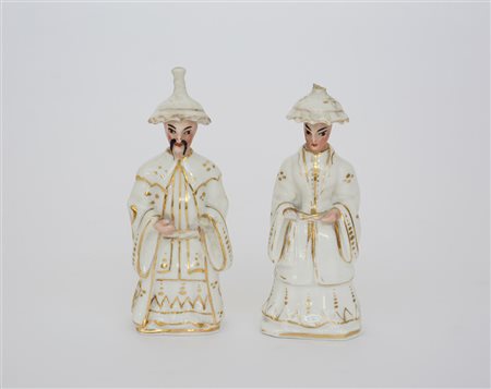 Coppia di sculturine in porcellana raffiguranti figure orientali con volti...
