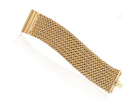 BRACCIALE A MAGLIA IN ORO GIALLO, ANNI ‘50 disegnato come un’alta fascia in...