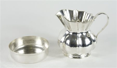 Lotto in argento martellato composto da ciotola rotonda e brocca con manico....