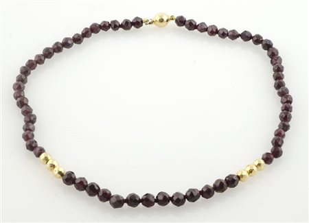 Collana di granati intervallati da palline in oro giallo.