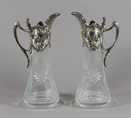 Coppia di brocche in cristallo inciso con montatura in metallo sbalzato e...