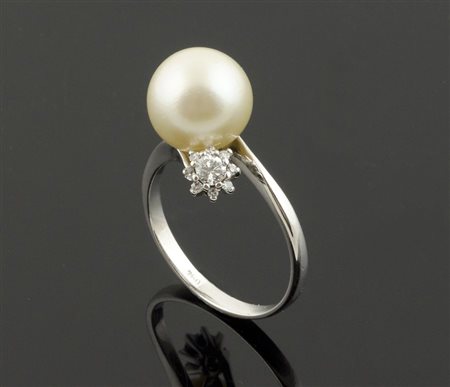 Anello in oro bianco con perla centrale e 2 brillanti ai lati.