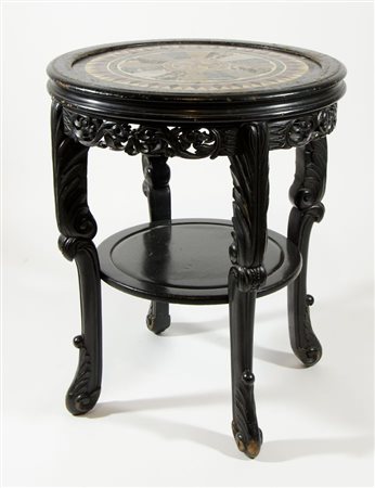 Tavolo rotondo in legno scuro con piano in marmi intarsiati. H. cm. 82, diam....