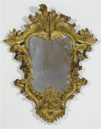 Specchiera sagomata in legno dorato scolpito. cm. 49x40.