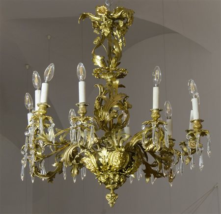 Grande lampadario in bronzo dorato a 12 luci riccamente decorato a motivi di...