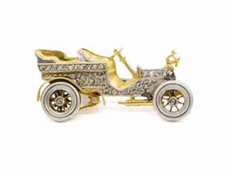 Spilla in oro bianco e giallo, gr. 5,90, a guisa di automobile con diamanti.