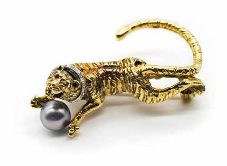 Spilla in oro giallo, gr. 14,9, a guisa di tigrotto con diamanti e perla grigia.