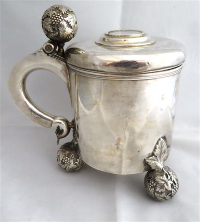 TANKARD In argento, corpo cilindrico poggiante su tre sfere lavorate....